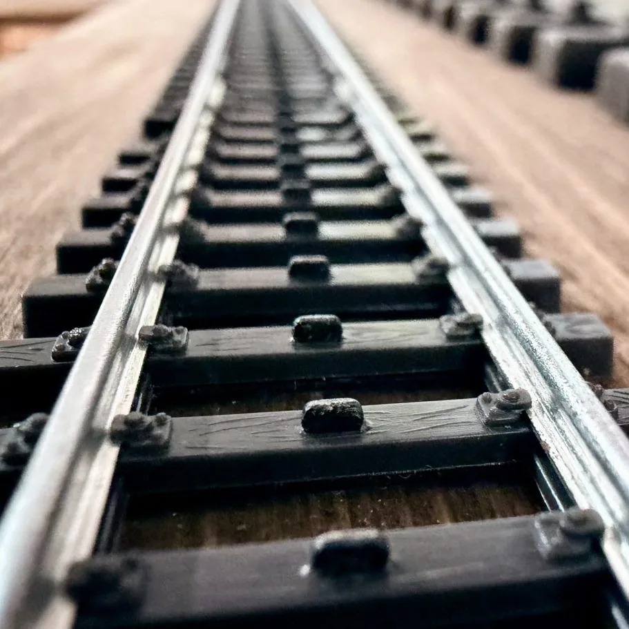 Gleise, parallel verlaufende Schienen auf Holzplatte.