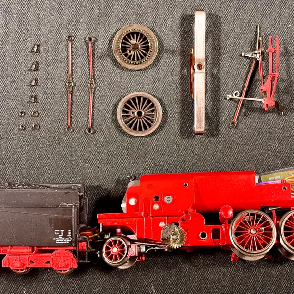 Ein Märklin-Lok wird mit einem Schraubendreher von Hand zusammengebaut.