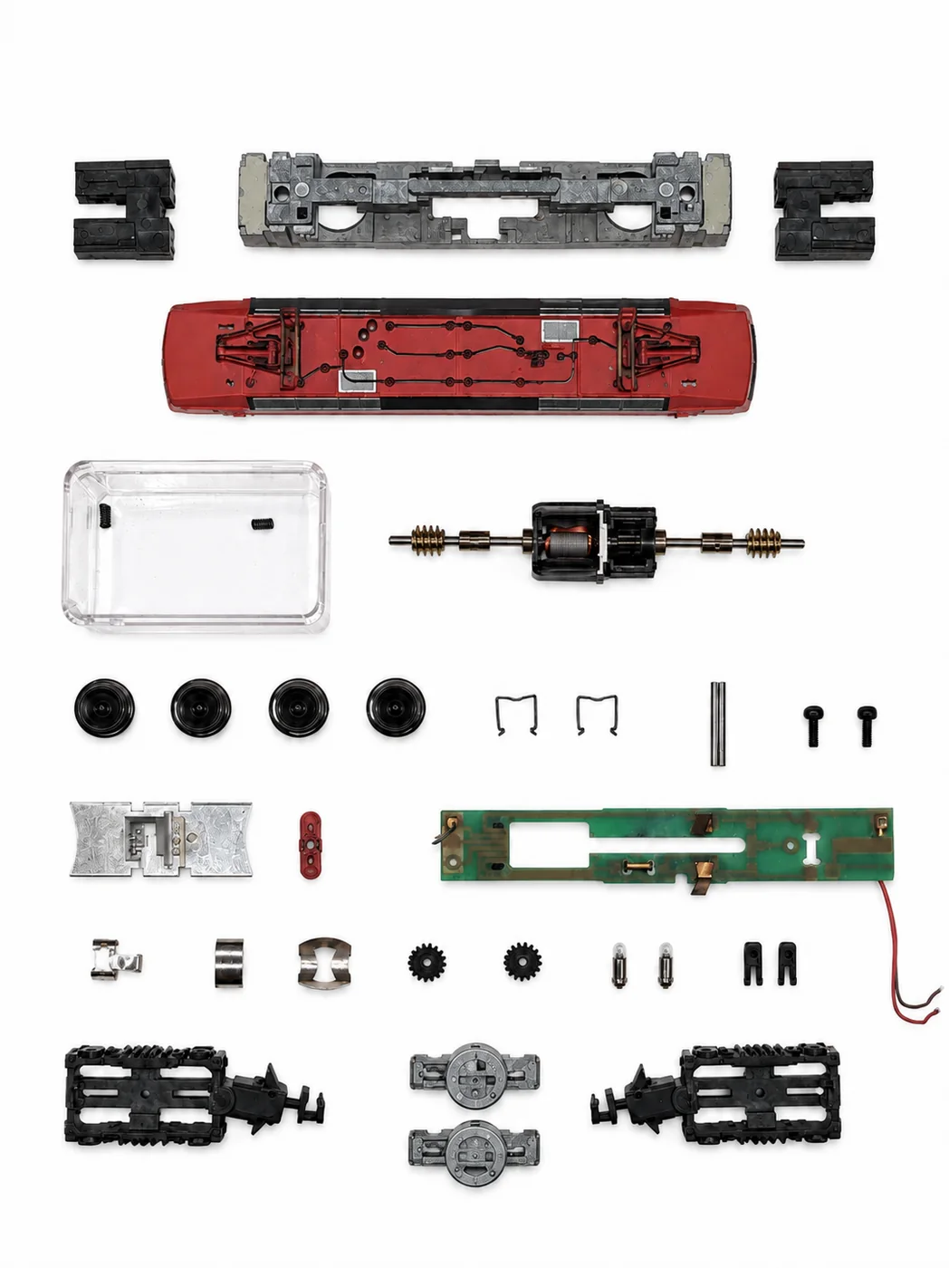 Vollständig zerlegte Minitrix BR 120 in Spur N: Metallrahmen, rotes Gehäuse, Motor mit Schwungmasse, Drehgestelle, Räder, Platine und Kleinteile nebeneinander aufgereiht.