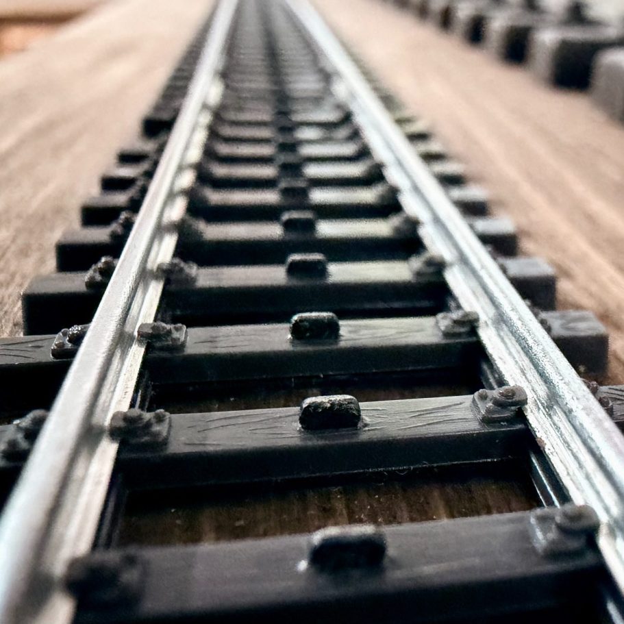 Gleise, parallel verlaufende Schienen auf Holzplatte.