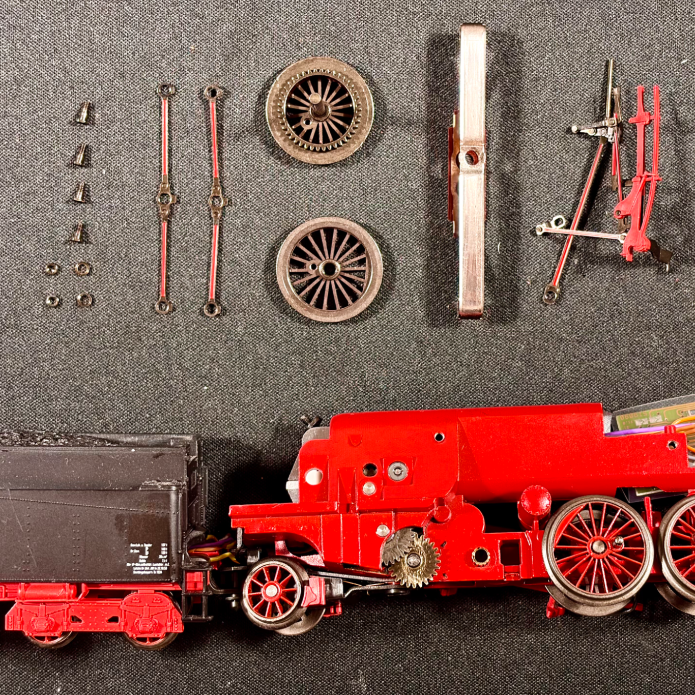 Ein Märklin-Lok wird mit einem Schraubendreher von Hand zusammengebaut.