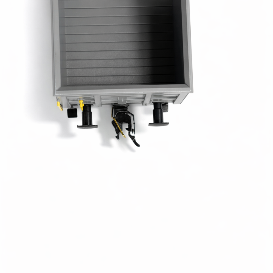 Zwei Modelleisenbahnwagen nebeneinander: ein Güterwagen und ein Zementmischer mit stromführenden Kupplungen.